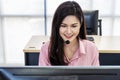 Service desk consultant talking on hands-free phone,  Portrait of a smiling young female customer support executive working Royalty Free Stock Photo