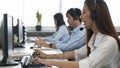 Call center young employee working with headset, Smiling customer support operator team at work surrounded Royalty Free Stock Photo