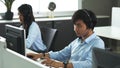 Call center young employee working with headset, Smiling customer support operator team at work surrounded Royalty Free Stock Photo