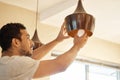 They call me the handy man. a young man replacing a light bulb at home. Royalty Free Stock Photo