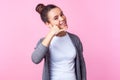 Call me! Portrait of beautiful brunette teen girl smiling playfully, making phone gesture. isolated on pink background Royalty Free Stock Photo