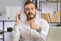 Young business man showing smartphone asking to make telephone conversation gesturing call me sign Royalty Free Stock Photo