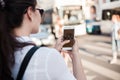 Call a taxi using the mobile application. A young woman in the city is standing near the road with a smartphone Royalty Free Stock Photo