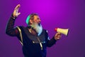 Funny old grey-bearded man in image of medieval warrior or knight in period costume shouting at megaphone isolated o Royalty Free Stock Photo