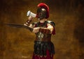 Portrait of medieval person, young man, warrior or knight in war equipment isolated on vintage dark background Royalty Free Stock Photo