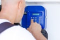 Call using public phone male tourist dials phone number in white t-shirt Royalty Free Stock Photo