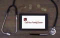 Call Your Family Doctor. Text on tablet device on a wooden table