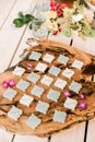 Calligraphed place cards for dinner arrranged on a wooden plank