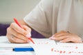 Calligrapher student practices in writing word LOVE with red marker on canvas. Creative artist freelancer working on