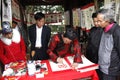 Calligraphers writing art letters for visitors in temple