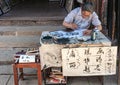 Calligraphy Artist at table in street of Tongli, China