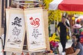 Calligraphy hanging for sale on the roadside and yellow apricot blossom background in Tet holiday