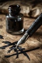 Calligraphy Pen Creating Bold Strokes on Textured Parchment with Ink Bottle Royalty Free Stock Photo