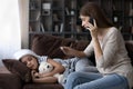 Sick preteen girl lie on couch while mother calling doctor Royalty Free Stock Photo