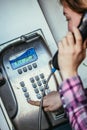 Calling home in the holidays: Young girl speaks in an old fashioned pay phone Royalty Free Stock Photo