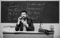 Calling parents. School teacher call mobile phone while sit classroom chalkboard background. Teacher bearded man talk