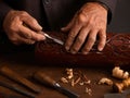 Calloused hands of an elderly woodworker using a chisel to carve intricate patterns on a piece of wood. Craftsmanship, tradition, Royalty Free Stock Photo