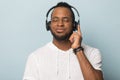 Calm African American man in headphones enjoying favorite music