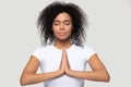 Calm African American woman practicing yoga, meditating, namaste gesture