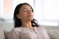 Calm African woman resting closed eyes breathing fresh humidified air