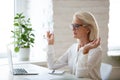 Calm aged woman meditate with mudra hands in office