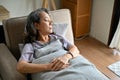 Calm Asian aged-woman lying on her sofa, sleeping or taking an afternoon nap in her living room Royalty Free Stock Photo