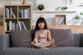 Calm of Asian child cute making yoga meditation with inhale and exhale. Sit on couch for focusing mind and soul. Relaxed with hand