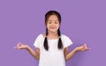 Calm Asian Kid Girl Meditating Standing Over Purple Background Royalty Free Stock Photo