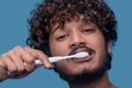 Calm attractive guy cleaning his teeth with a toothbrush Royalty Free Stock Photo