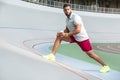 Calm attractive young man in sportswear stretching muscles