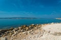 Calm beach of Crikvenica with stones under blue sky