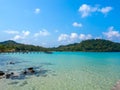 Calm beach scene, movement of blue sea water and wave surf, wooden bridge, group of rocks on clean sandy beach ocean, sea shore. Royalty Free Stock Photo