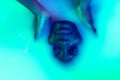 Close up female face of african girl in milk bath with soft white glowi in neon light. Modern neoned colors, foam