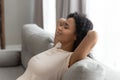 Calm black young woman relax on sofa hands over head Royalty Free Stock Photo