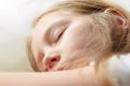 Calm blond child girl sleeps on white soft pillow in comfortable cozy bed Kid closed eyes portrait close-up Sleeping app