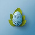 a calm blue easter egg with leaves on blue background Royalty Free Stock Photo