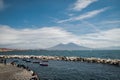 Calm blue Tyrrhenian Sea. View from the embankment of Naples to Mount Vesuvius volcano. Pleasure boats moored near the stone Royalty Free Stock Photo