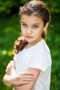 Calm brunette little girl in summer park