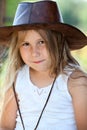 Calm Caucasian young girl in cowboy leather hat, blond child looking at camera Royalty Free Stock Photo