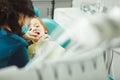 Calm child in dental office allows the dentist to examine teeth. Boy is treated for caries.