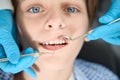 Calm child on examination in the dental office, the dentist uses special tools