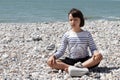 Calm child meditating for inner peace, wellbeing and wisdom, beach