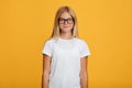Calm confident pretty european teenager girl in white t-shirt and glasses looking at camera Royalty Free Stock Photo