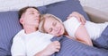 Calm couple sleeping and spooning in bed in bedroom at home