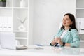 Calm dreaming smiling millennial caucasian lady in suit resting at workplace with cup of tea Royalty Free Stock Photo