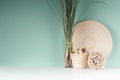 Calm eco home decor with natural beige dried plant, wicker basket, bamboo plate, bunch of reed in glass bottle, sheaf of twigs.