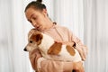 Woman stroking obedient Jack Russell Terrier dog in hands