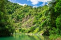 Calm green waters of mountain river flowing along a forested cliffs. Waioeka Gorge, North Island, New Zealand Royalty Free Stock Photo