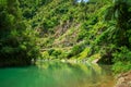 Calm green waters of mountain river flowing along a forested cliffs. Waioeka Gorge, North Island, New Zealand Royalty Free Stock Photo