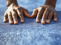 Hands of a person resting on a textured blue yoga mat preparing for a mindful meditation or stretching exercise session indoors Royalty Free Stock Photo